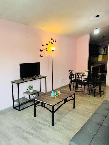 a living room with a table and a tv at La Casita in Pátzcuaro