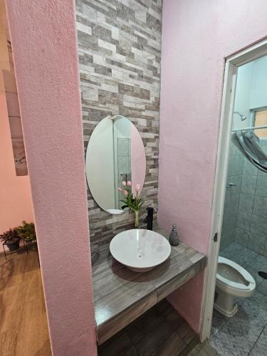 een badkamer met een wastafel en een spiegel bij La Casita in Pátzcuaro