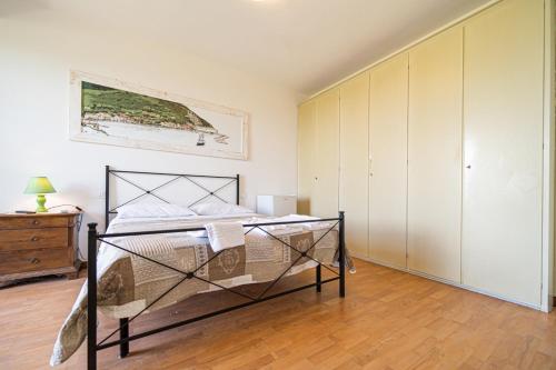 een slaapkamer met een bed en een dressoir bij Villa Ray in Capoliveri