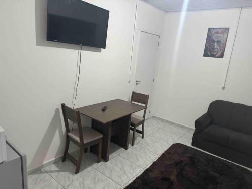 a living room with a table and a couch at Studio novo 2024 próx. Aeroporto in Passo Fundo