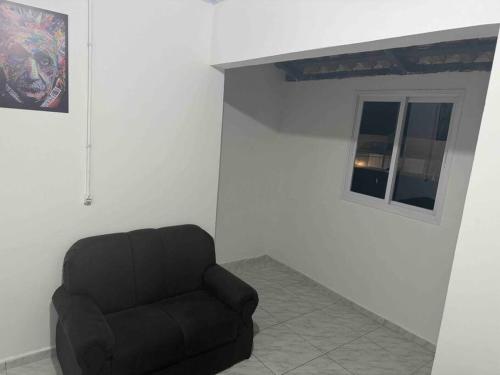 a black chair in a room with a window at Studio novo 2024 próx. Aeroporto in Passo Fundo