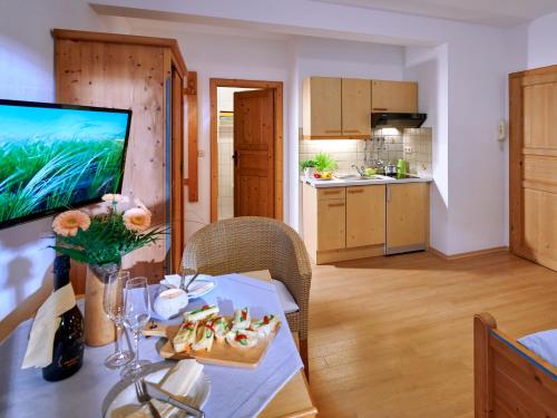 une cuisine et une salle à manger avec une table et une télévision dans l'établissement Beim Paulfischer, à Chieming
