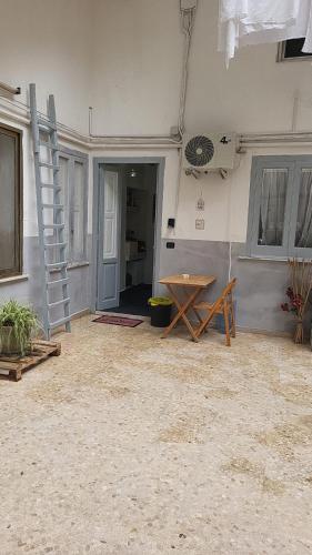 a room with a table and a ladder and a table at the lighthouse accommodation in Taranto