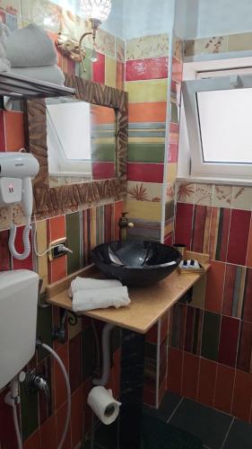 a bathroom with a black sink and a mirror at the lighthouse accommodation in Taranto