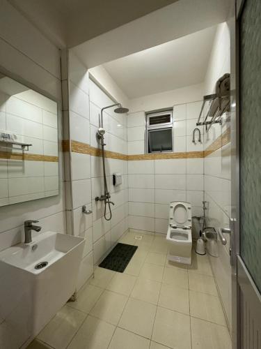 a white bathroom with a sink and a toilet at Kampala Executive Suites in Kampala