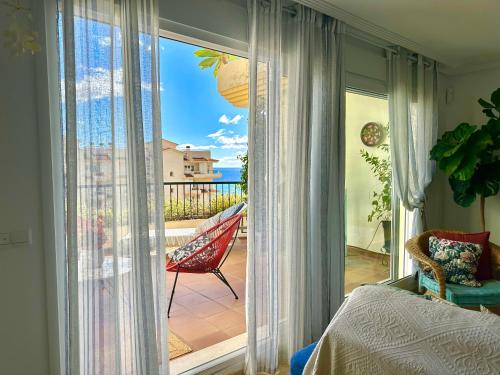 a bedroom with a balcony with a view of the ocean at Can Luc Altea in Altea