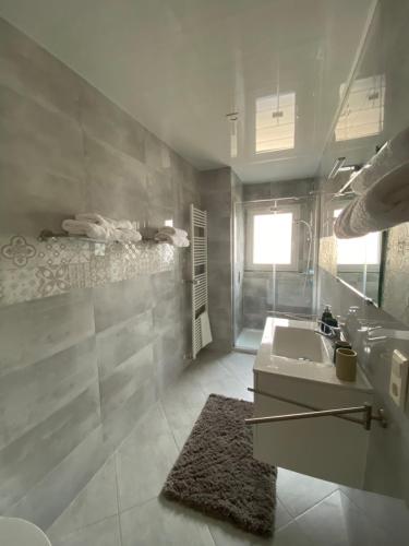 a white bathroom with a sink and a mirror at Pension mit Moselblick in Klotten