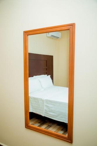 a mirror reflecting a bed in a bedroom at ANINY HOTEL in Dar es Salaam