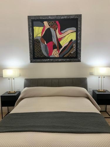 Un dormitorio con una cama con un cuadro en la pared. en Bari Downtown Luxury Apartment, en Bari