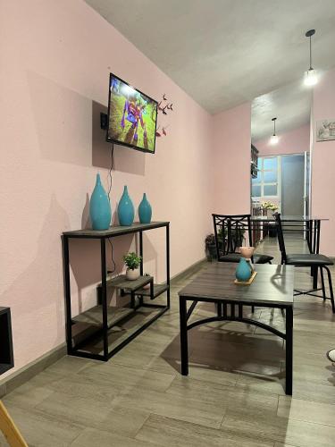 a living room with tables and vases on the wall at La Casita in Pátzcuaro