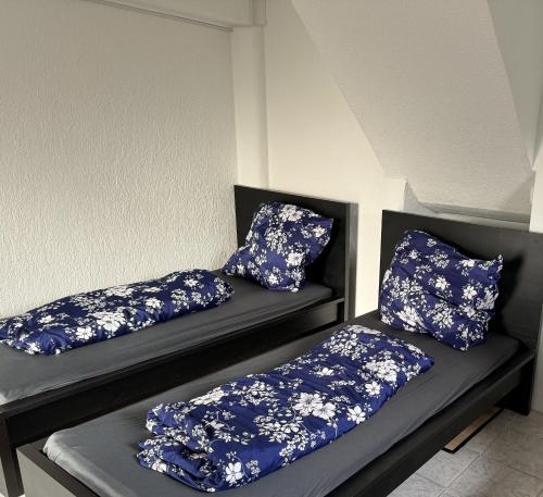 two beds with blue and white pillows on them at Schönes Apartment mit TV, WLAN, Kochbereich und Parkplatz - Sara in Werne an der Lippe