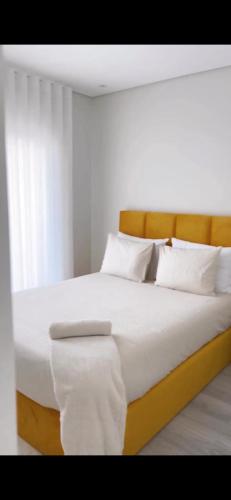 1 cama grande con sábanas y almohadas blancas en Home Silva Sanches en Quinta do Conde