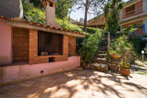 a brick building with a fireplace in a yard at Villa Ray in Capoliveri