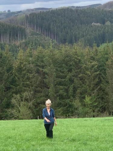 a woman standing in a field with a frisbee at Chalet am Weiher in Recht