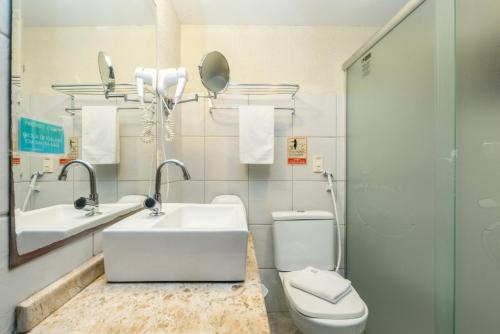 a bathroom with a sink and a toilet and a mirror at Pousada Recanto da Coruja in Porto De Galinhas