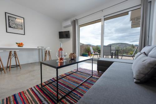 a living room with a table and a large window at Ikiesnafplio in Nafplio