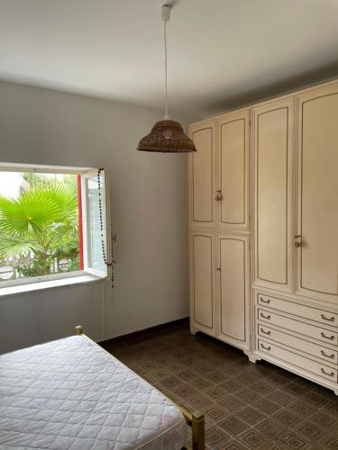 貝爾韋代雷的住宿－Villa Sasà，一间卧室设有一张床和一个窗口