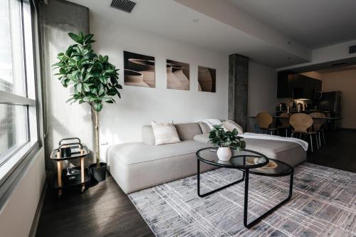 a living room with a white couch and a potted plant at Luxurious Hollywood condo in Los Angeles
