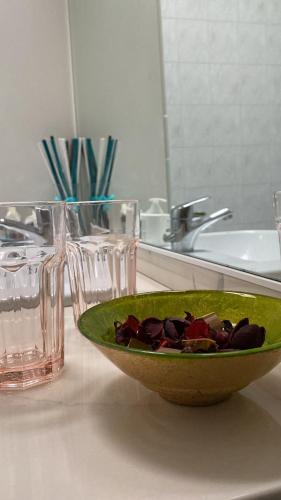 a green bowl of flowers on a counter next to a sink at via Cappuccini 2b - soggiorna in centro a Gorizia con ascensore in Gorizia
