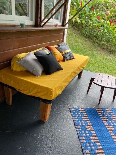 un banc avec des coussins dessus sur un porche dans l'établissement Location Mont Sofa, à Sainte-Rose