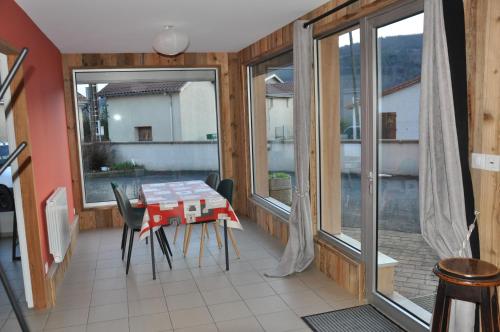 d'une salle à manger avec une table et quelques fenêtres. dans l'établissement La cadole de Clem, à Juliénas