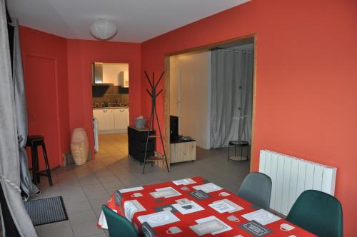 a living room with a table and a red wall at La cadole de Clem in Juliénas