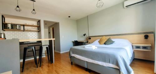 a bedroom with a large bed and a kitchen at Caseros Suite!! Hermoso Apart en Corredor turistico de Salta!! in Salta