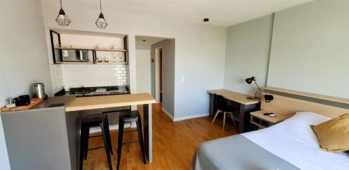a bedroom with a bed and a kitchen with a counter at Caseros Suite!! Hermoso Apart en Corredor turistico de Salta!! in Salta