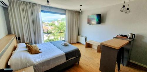a bedroom with a bed and a desk and a window at Caseros Suite!! Hermoso Apart en Corredor turistico de Salta!! in Salta