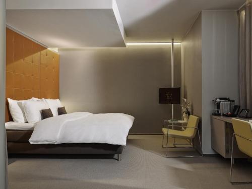 a hotel room with a bed and a desk and a desk at La Butte aux Bois a Small Luxury Hotel of the World in Lanaken
