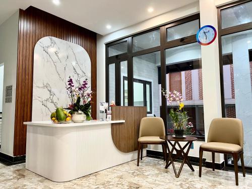 a lobby with a counter and chairs and a clock at SAFFRON Dalat in Da Lat