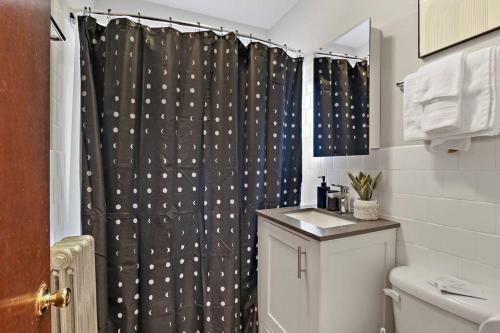 a bathroom with a black shower curtain and a sink at Elegant Studio Apt in Chicago - Dorchester 511 in Chicago