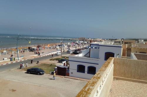 Blick auf den Strand mit Menschen und Autos in der Unterkunft Villa prêt de la plage in Souira Guedima