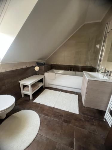 łazienka z umywalką, wanną i toaletą w obiekcie Galéria Apartmanház w mieście Keszthely
