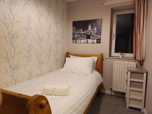 ein kleines Schlafzimmer mit einem Bett und einem Fenster in der Unterkunft Central Apartment in Belfast City Centre in Belfast