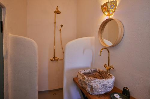 a bathroom with a sink and a mirror on a table at Agafay Desert Hotel in El Karia