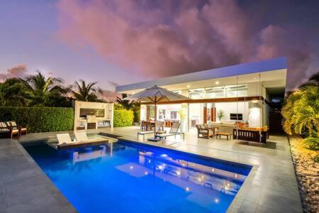 a large house with a large blue swimming pool at Beachside 2 Bedroom Villa with Pool and Resort Amenities - White Villas - v7 in Providenciales