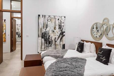 a bedroom with two beds and a painting on the wall at Beachside 2 Bedroom Villa with Pool and Resort Amenities - White Villas - v7 in Providenciales