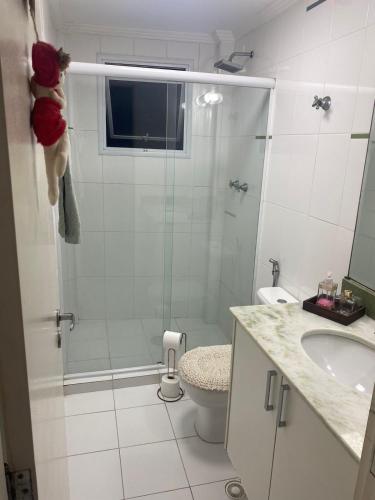 een badkamer met een douche, een toilet en een wastafel bij AP do JP in Praia Grande