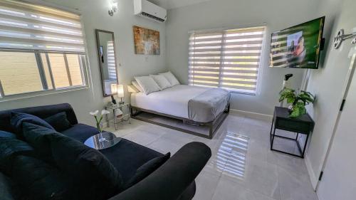 a living room with a bed and a couch at Elegant Oasis by the Sea in Saint Annʼs Bay