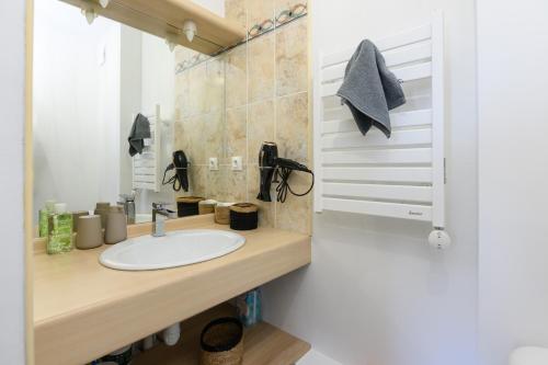 La salle de bains est pourvue d'un lavabo et d'un miroir. dans l'établissement Chartres Charmant Studio Meublé, à Chartres