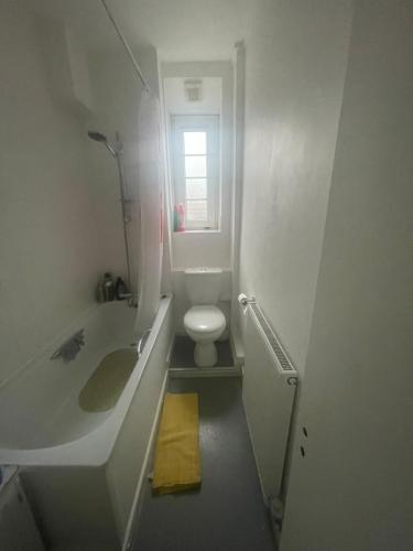 a small bathroom with a toilet and a sink at Super Streatham Room in London