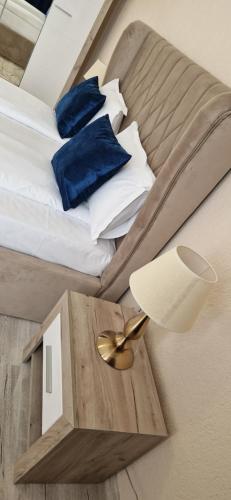 - une chambre avec 2 lits dotés d'oreillers bleus et d'une lampe dans l'établissement ORI ELEGANCE Malul Muresului, à Arad