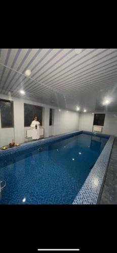 a large swimming pool with a man sitting at a desk at Moonglade Allure Houses in Polyana