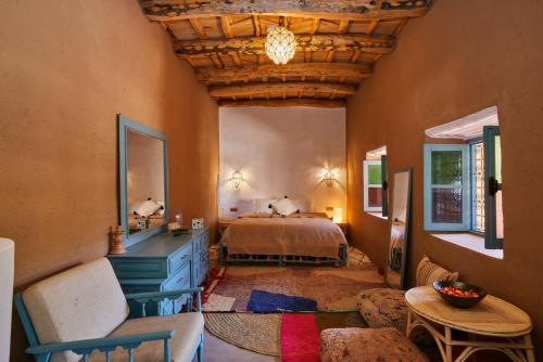 a bedroom with a bed and a table in a room at Agafay Desert Hotel in El Karia