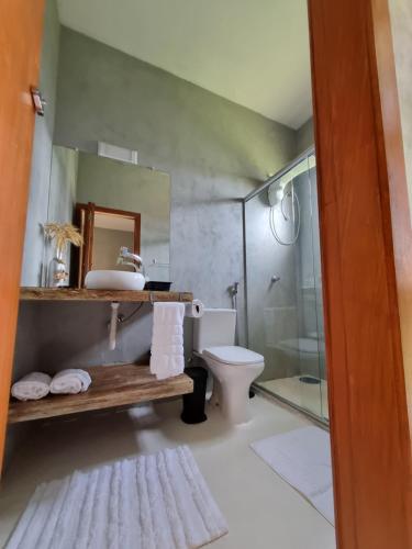 een badkamer met een wastafel, een toilet en een douche bij Pousada TAUANE in Caraíva