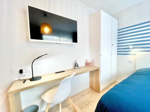 洛里昂的住宿－A L'ABORDAGE APPART - Lorient centre - Au calme，一间卧室配有书桌、一张床、一张床和一把椅子