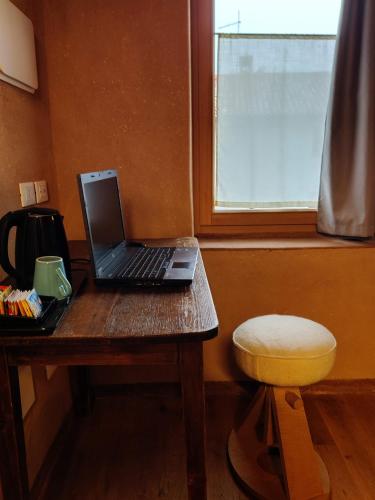 a laptop computer sitting on a wooden table next to a window at Casa Zefìra in Feltre
