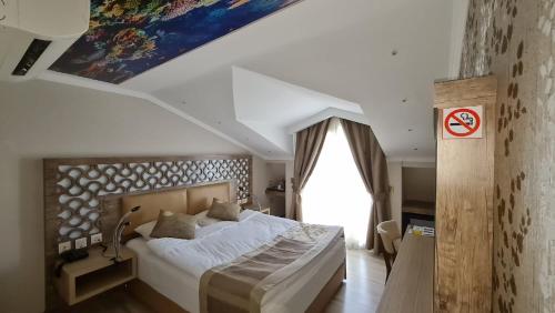 Un dormitorio con una cama grande y una ventana en Unluselek Hotel en Anamur