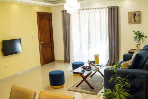 Confortable apartamento- Cotuí في Cotuí: غرفة معيشة مع أريكة وكراسي وتلفزيون